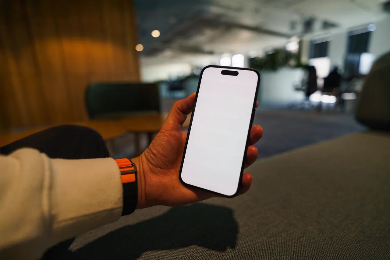 A hand holding a phone with the BizVault growth-plan chat on its screen